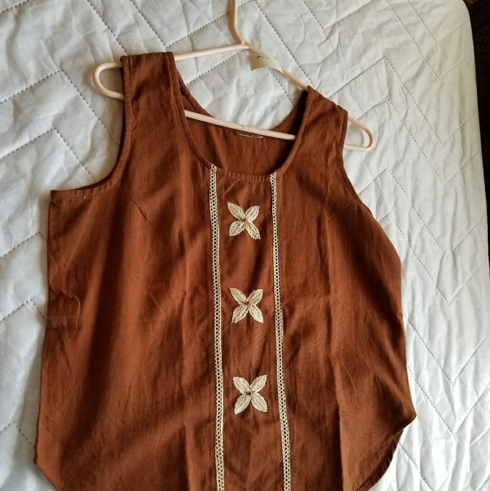 A brown tank top with flower patterns